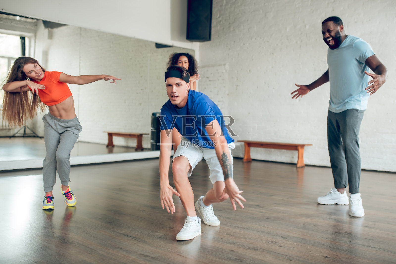 有纹身的开朗的家伙，朋友们在工作室跳舞照片摄影图片
