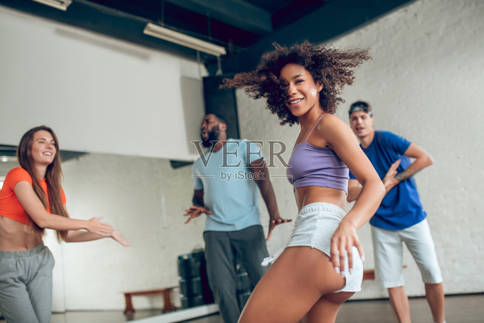 精力充沛的年轻女孩与朋友们跳舞照片摄影图片