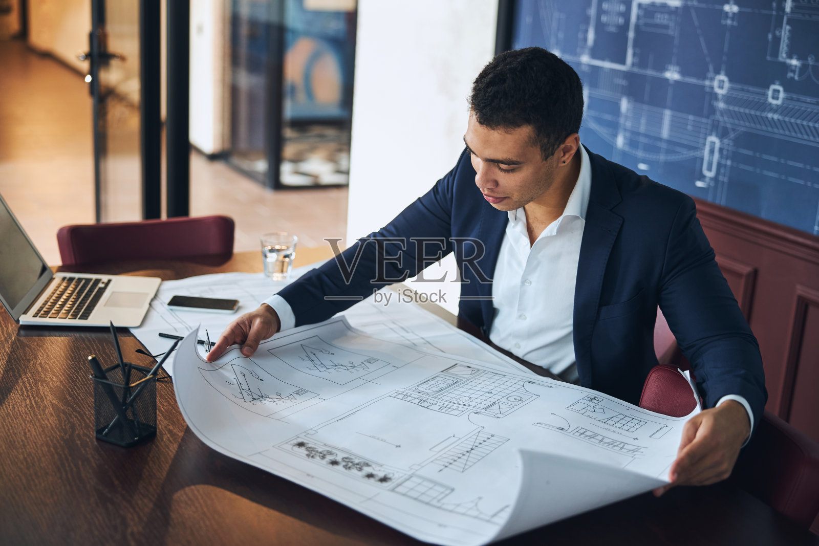 黑发的专业工程师仔细检查技术图纸照片摄影图片