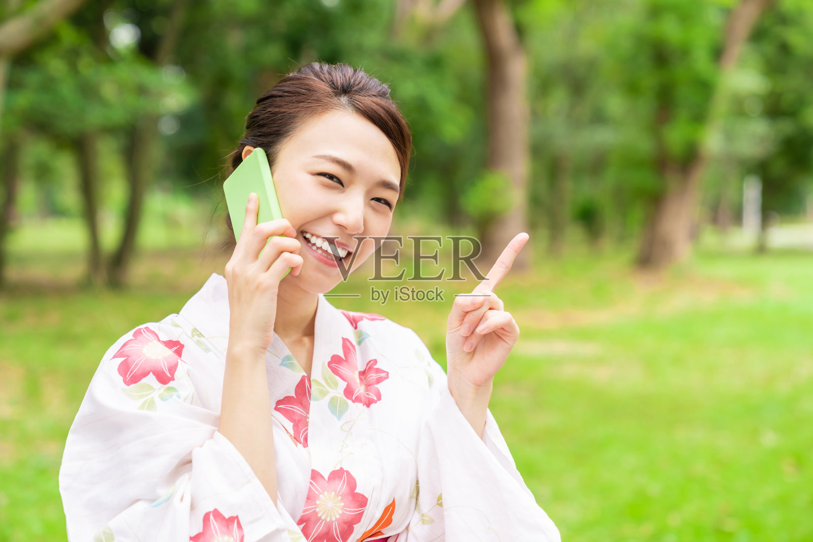 亚洲妇女穿着传统的日本夏季休闲和服，叫做“Yukata”，电话，照片摄影图片