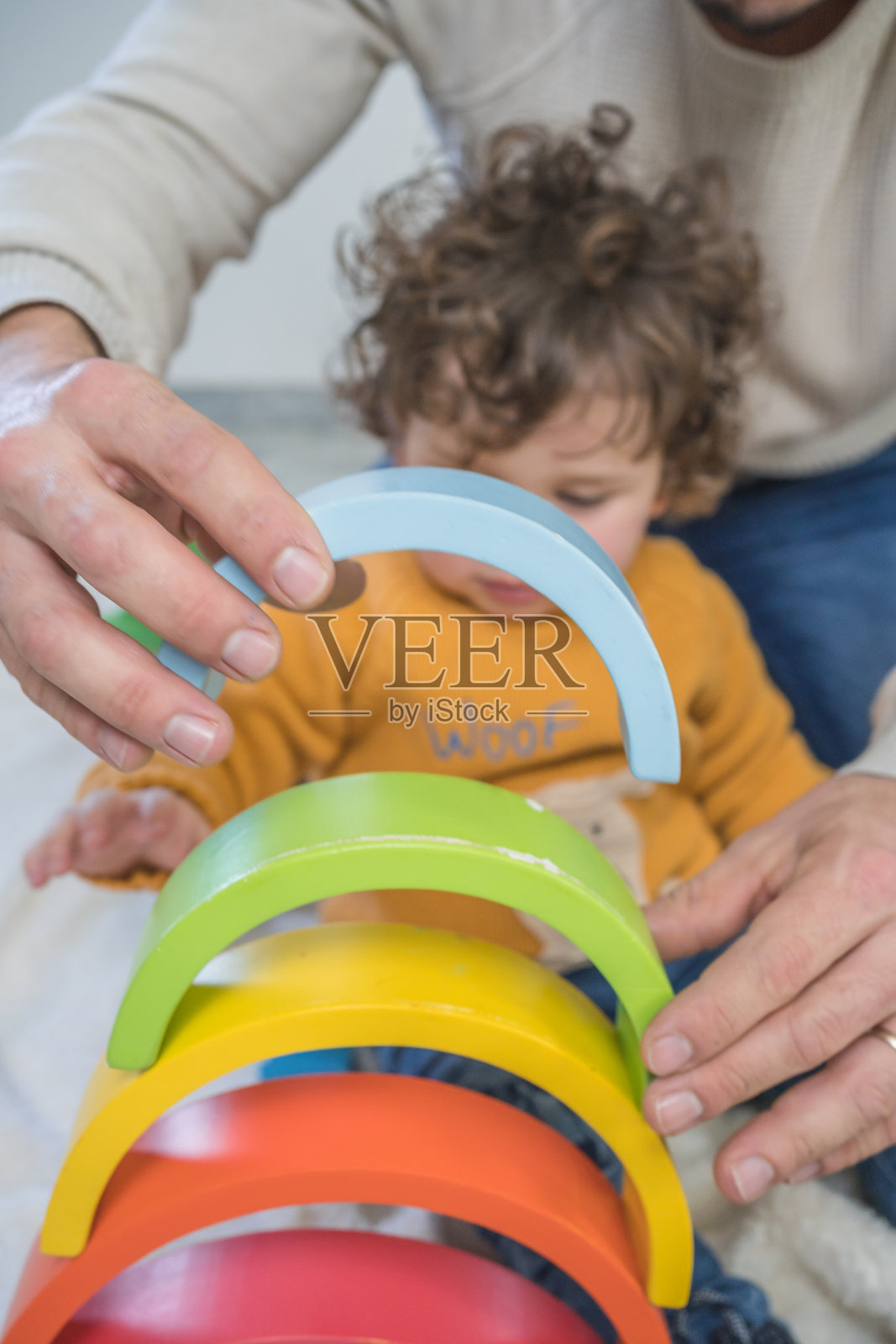 爸爸和儿子在家里的地板上玩黄色的毛衣，玩得很开心照片摄影图片