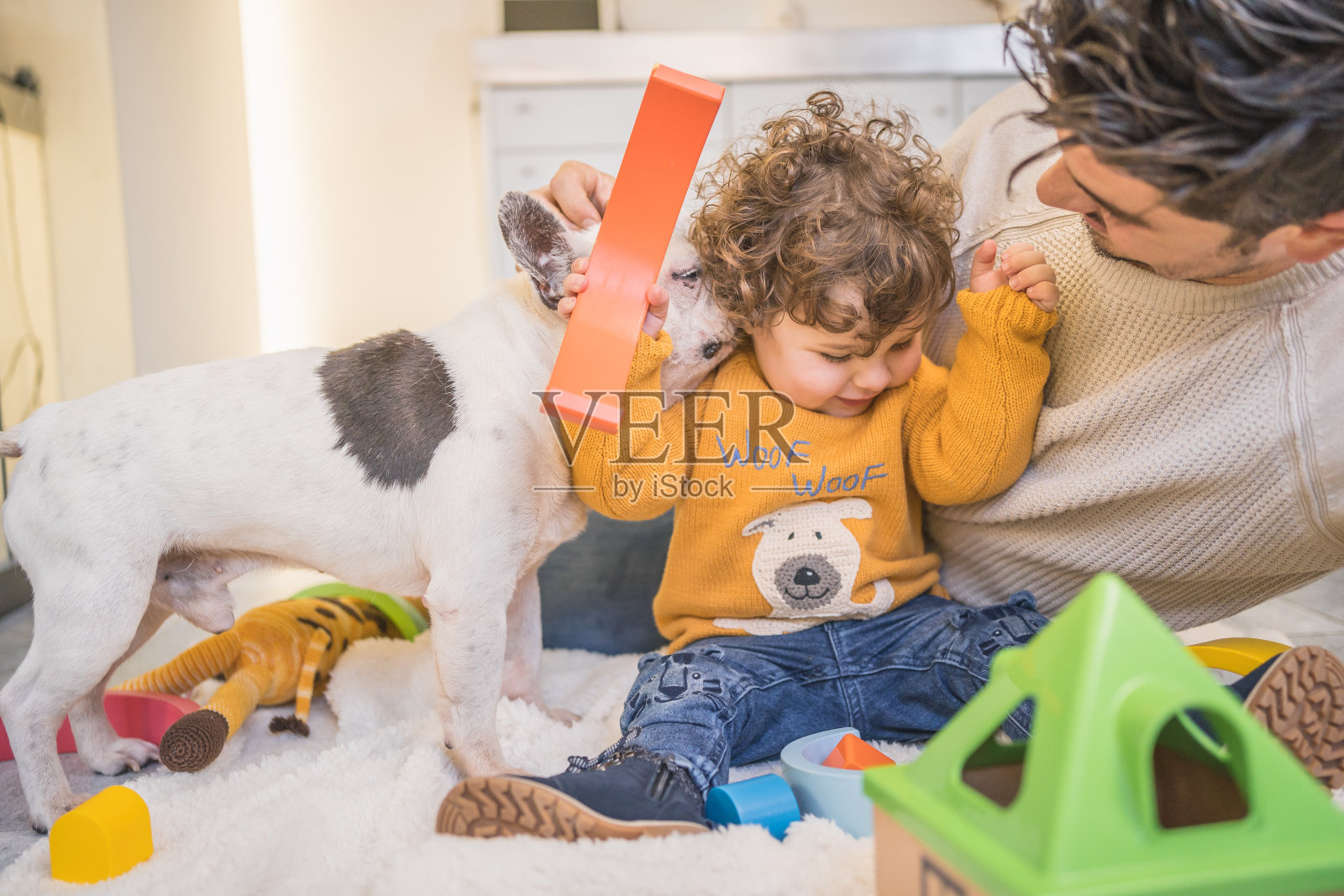 爸爸和儿子在家里的地板上玩黄色的毛衣，玩得很开心照片摄影图片