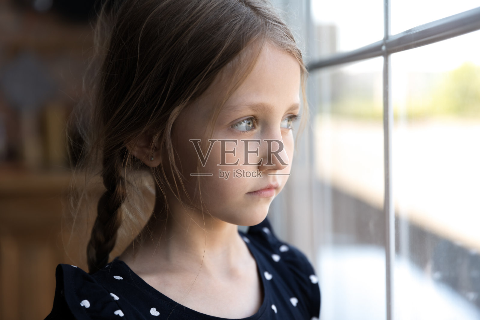 近不安，体贴的小女孩望着窗外照片摄影图片
