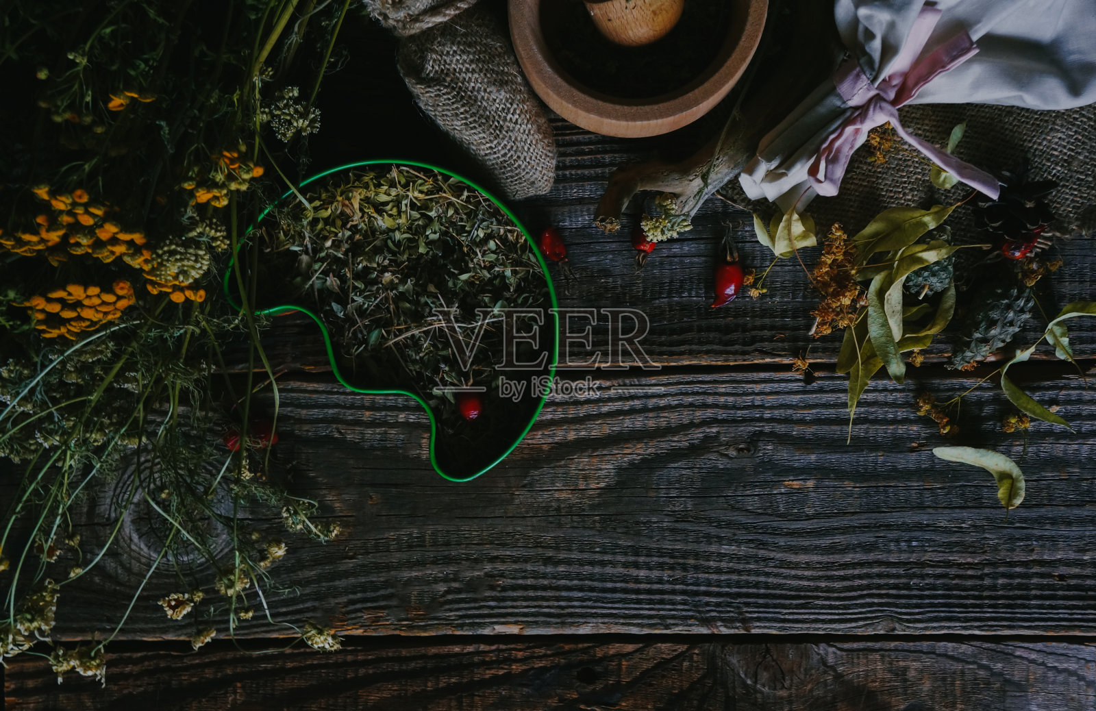 传统医学理念，古老的木桌上有草药和玫瑰果，照片摄影图片