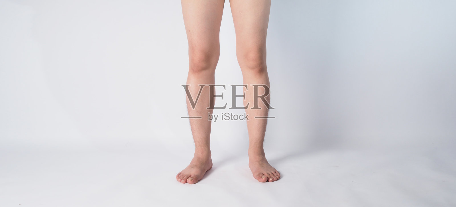 亚洲男性的腹股沟和腿和赤脚在白色的背景…照片摄影图片