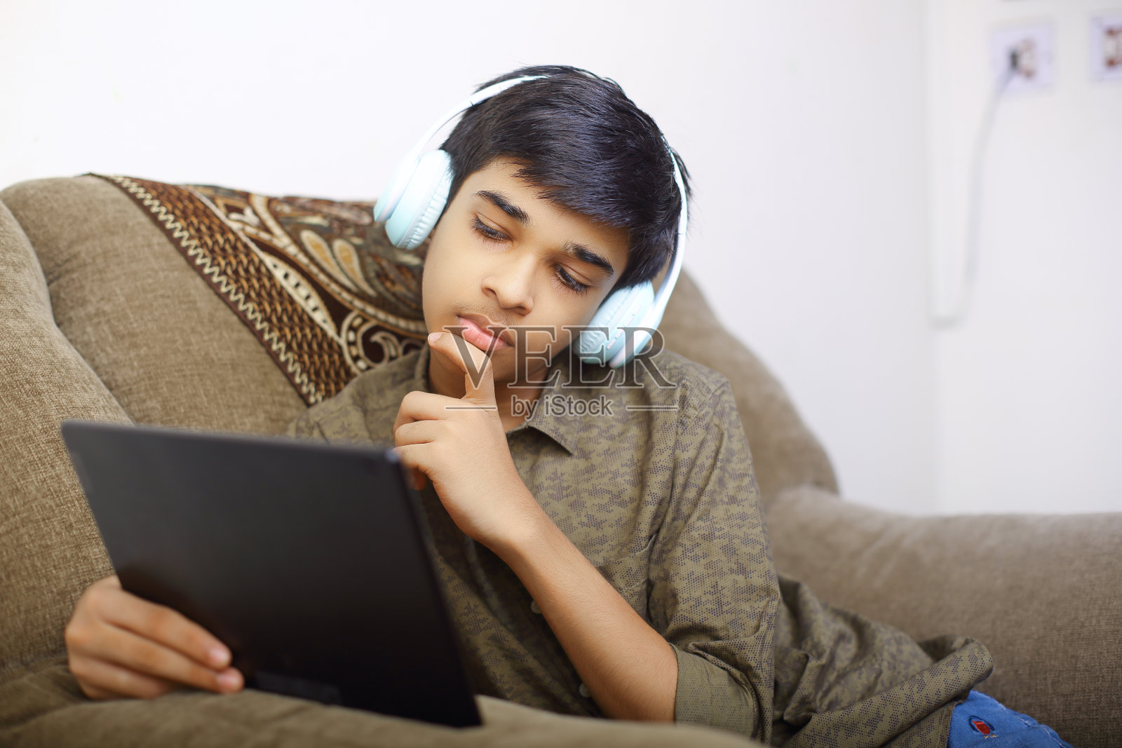 一名印度小男孩在家上在线课程时使用数字平板电脑照片摄影图片