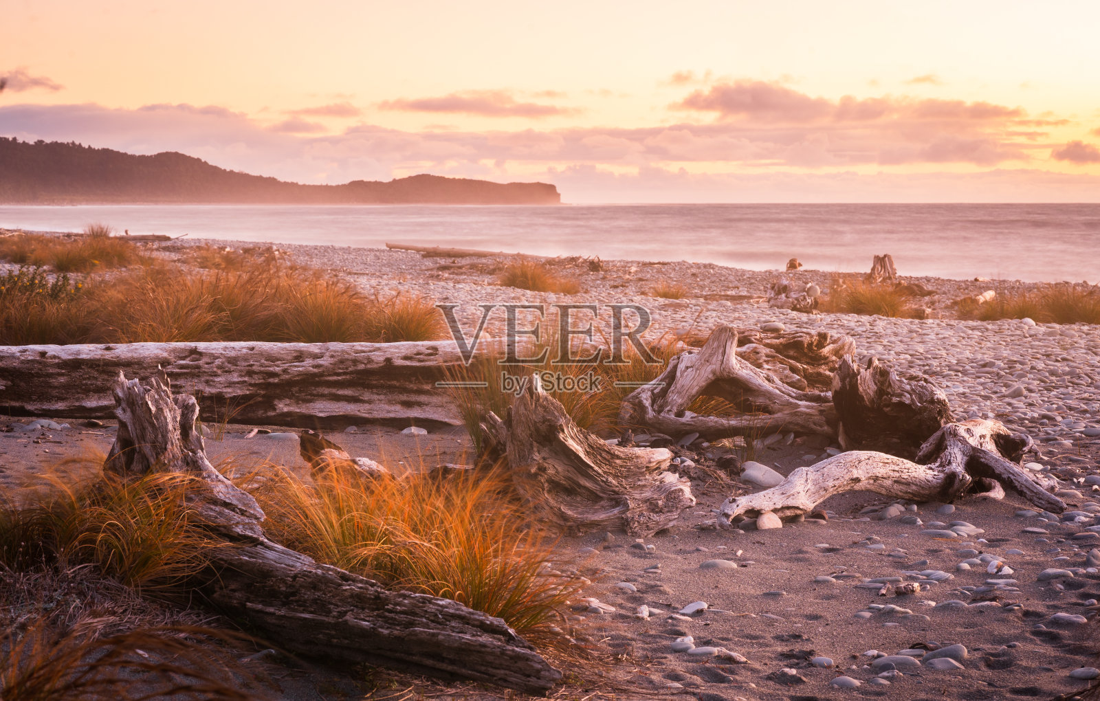 日落时波涛汹涌的海滩。照片摄影图片