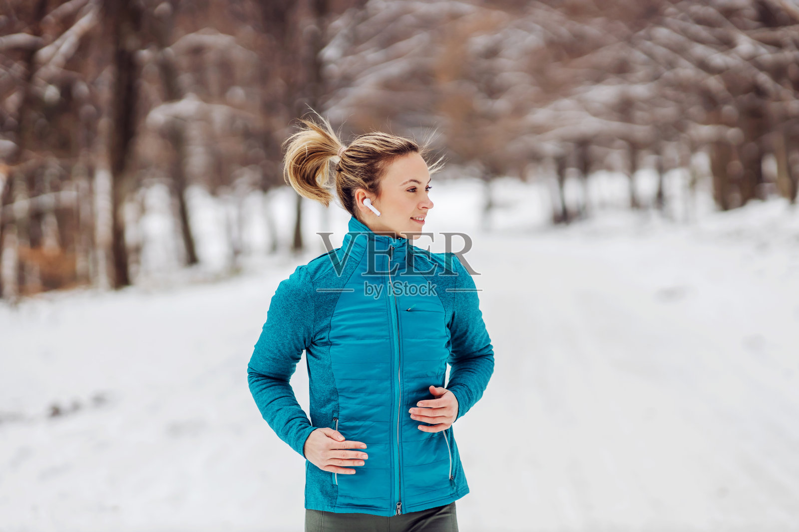 健康的女运动员在雪地上奔跑。天气冷，下雪，健康生活，健身照片摄影图片