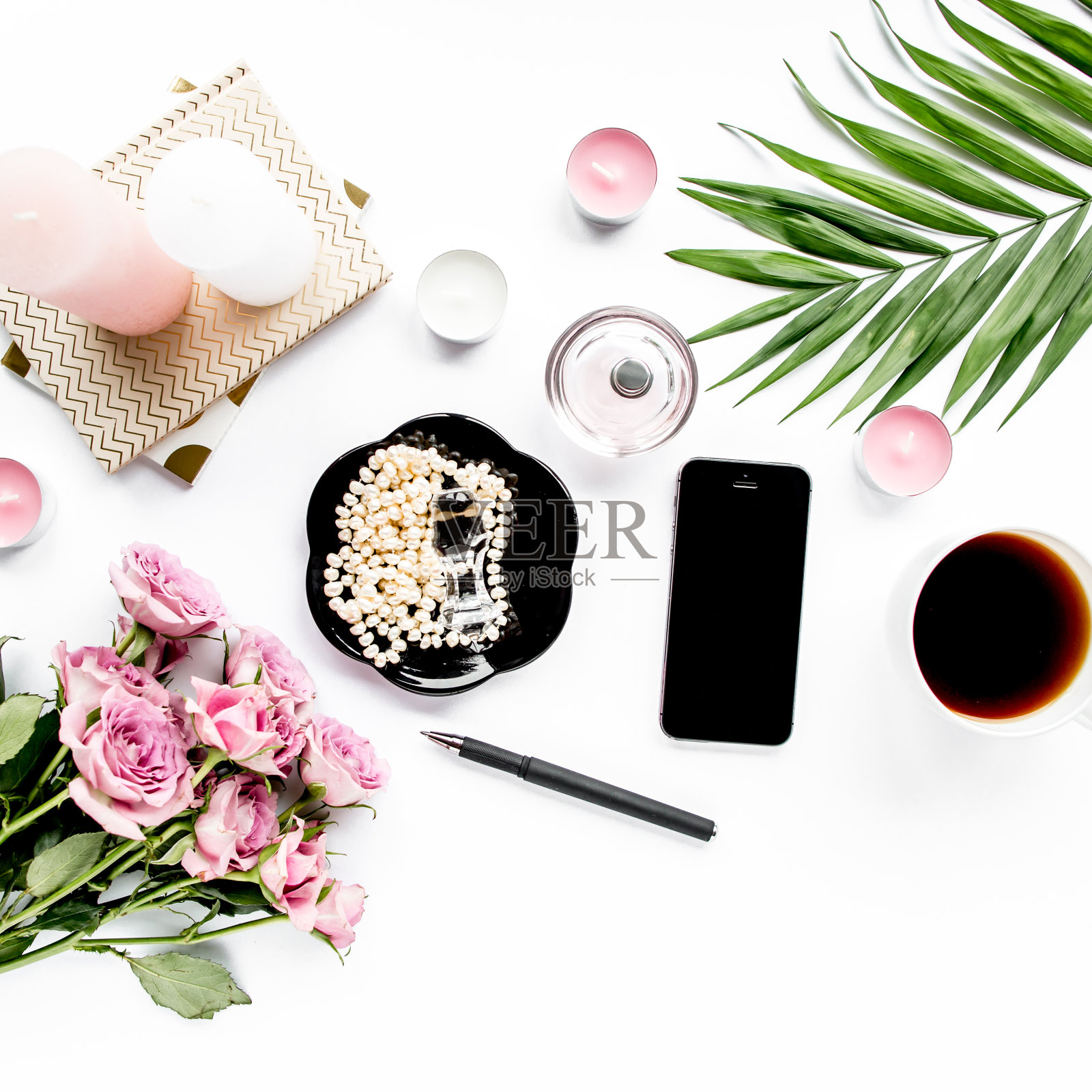 办公室桌子桌子上。工作空间与画笔，笔记本电脑，粉红色的花，手机在白色的背景。平面构成。俯视图，家庭办公空间照片摄影图片