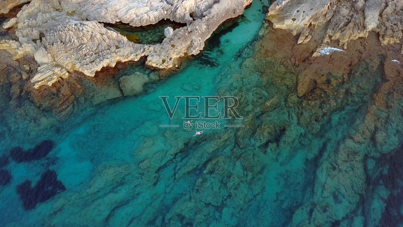 人们在落基海岸的绿松石海中游泳的航拍照片摄影图片