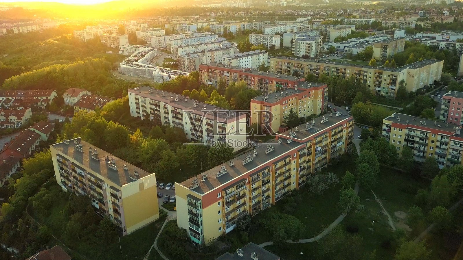 高空拍摄日落时分的住宅区，上面有公寓楼和住宅照片摄影图片