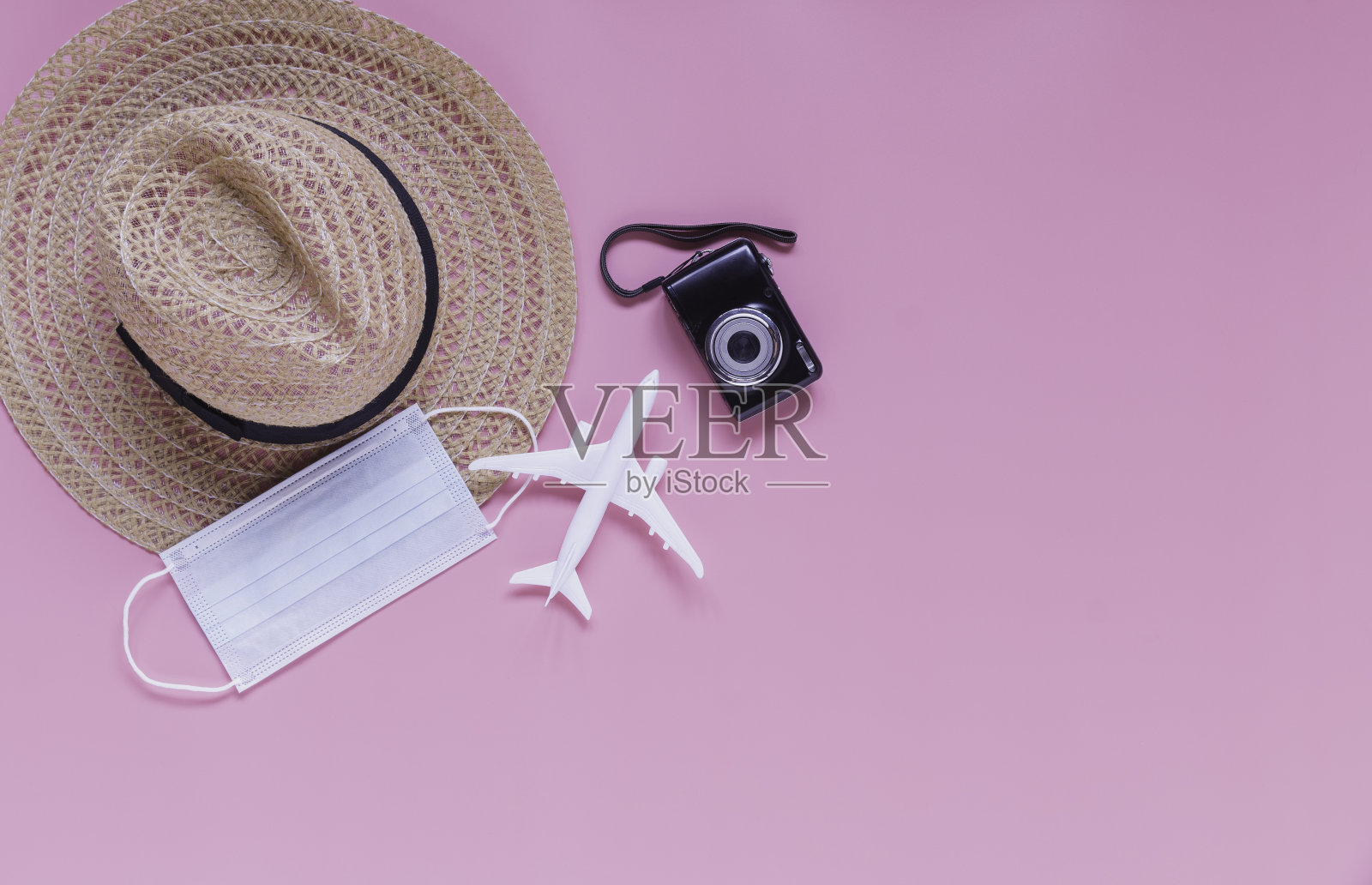 平铺旅行配件在粉红色的背景和旅行期间的covid-19疫情概念。照片摄影图片