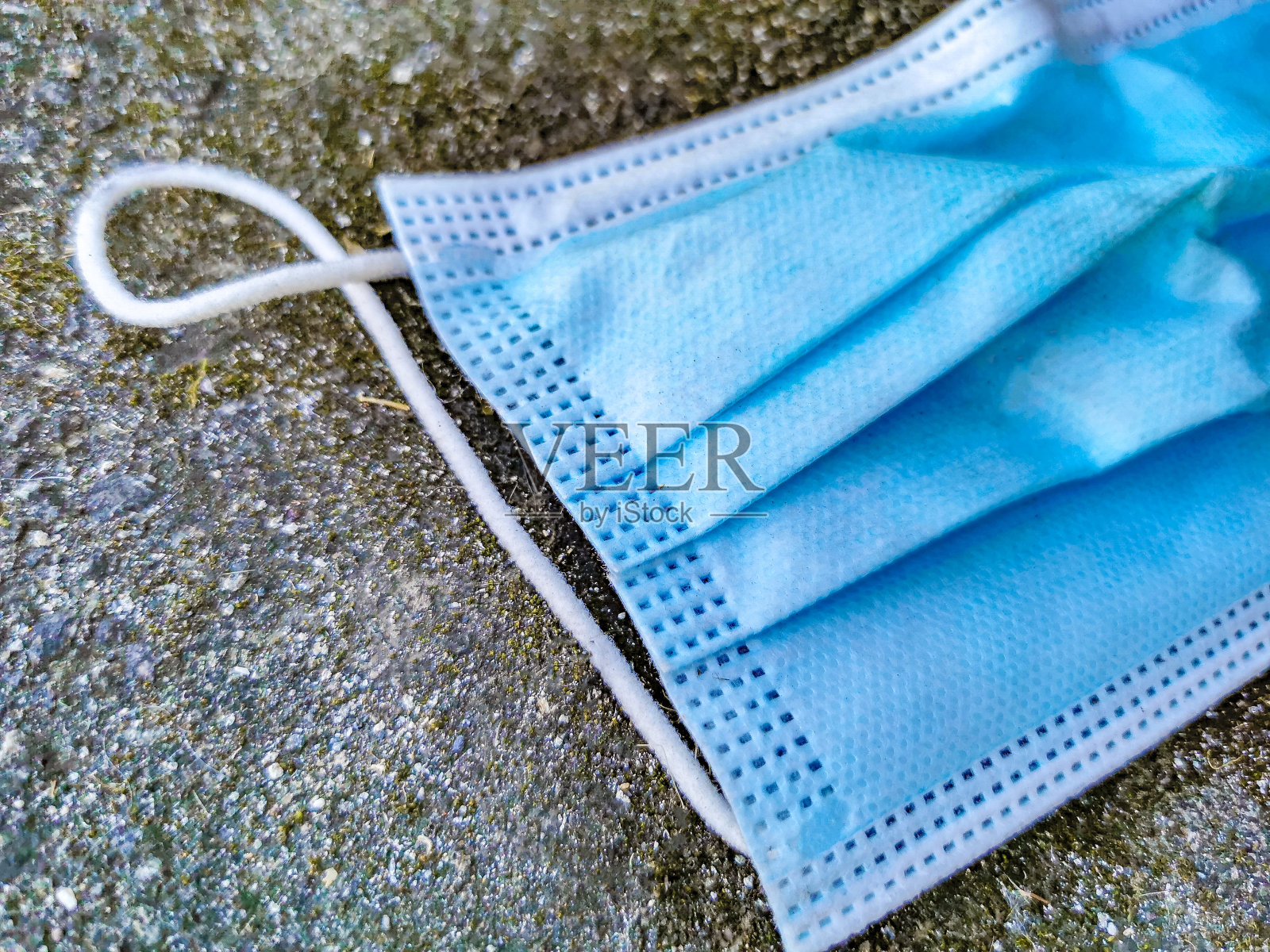 蓝色外科口罩在地上。冠状病毒污染。Covid19。照片摄影图片