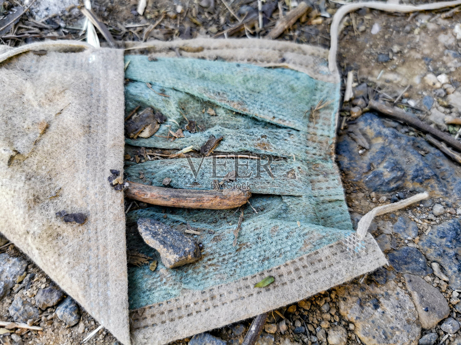 地上有肮脏的蓝色面具。冠状病毒污染。Covid19。照片摄影图片