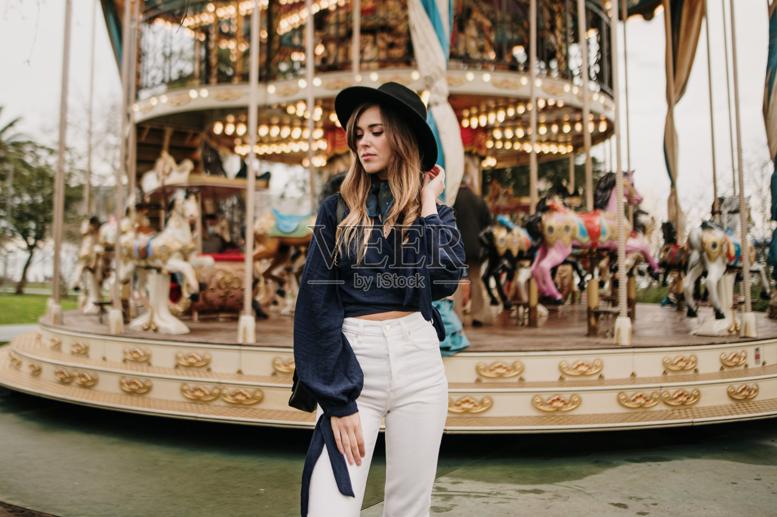 站在旋转木马旁的时髦女人照片摄影图片