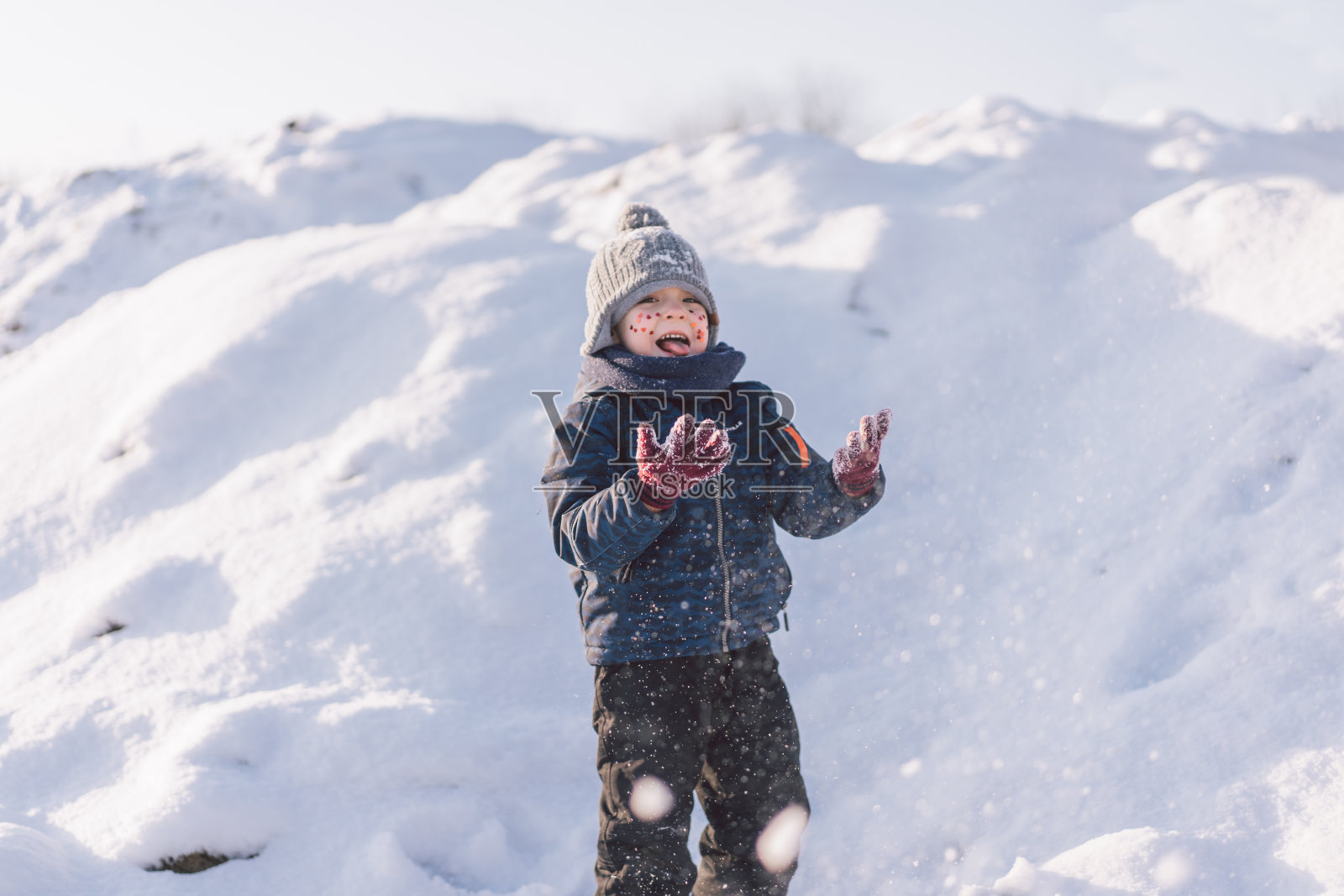 小男孩在玩雪。照片摄影图片