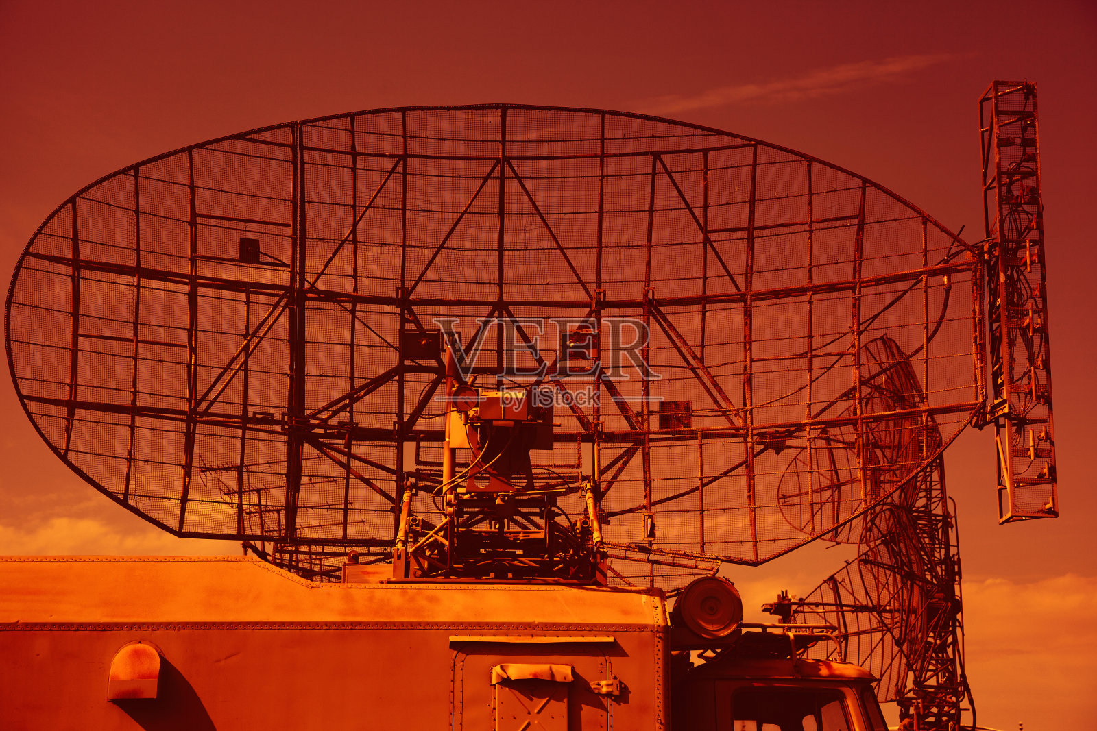 军用车辆车顶的军用雷达。在明亮的天空背景上的军事定位器照片摄影图片