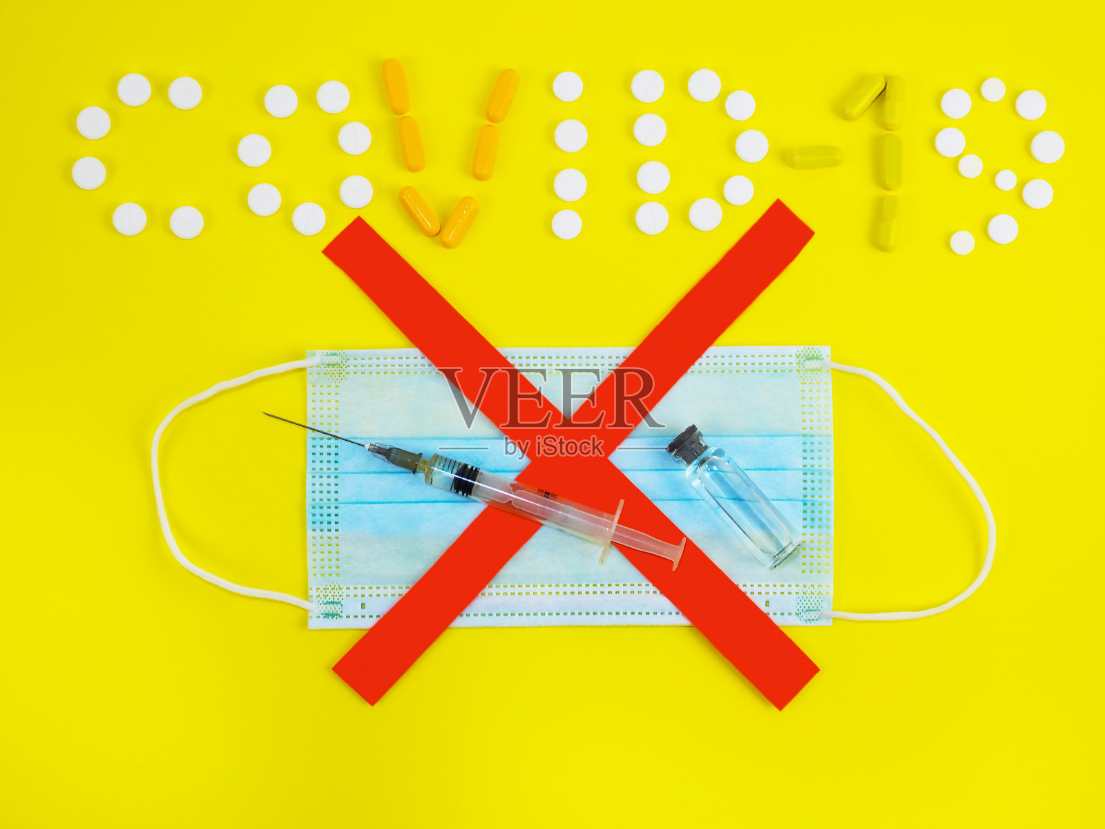 Covid-19这个词是用黄色背景的碑文写的。对接种疫苗。注射注射器，医用口罩，大流行期间的疫苗。Covid-19或冠状病毒疫苗。照片摄影图片