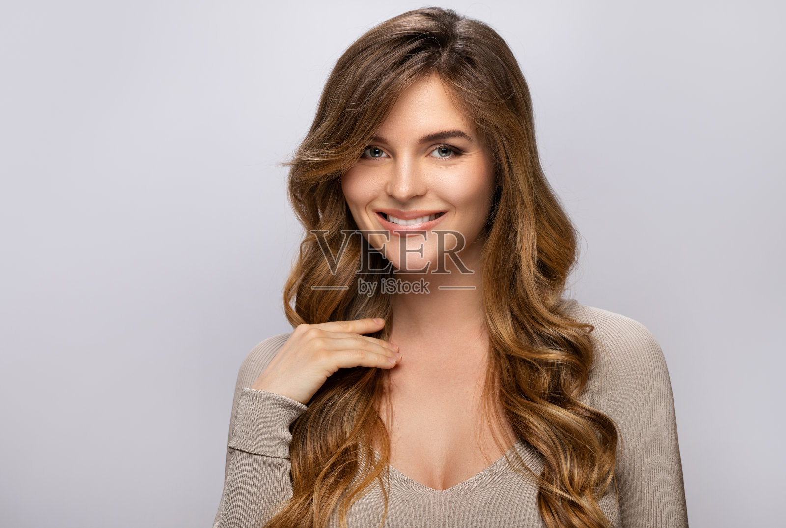 一个年轻漂亮的女人的肖像与卷曲的发型照片摄影图片