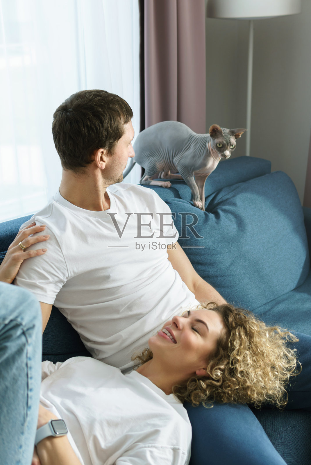 一对年轻夫妇和他们可爱的猫在家里放松照片摄影图片