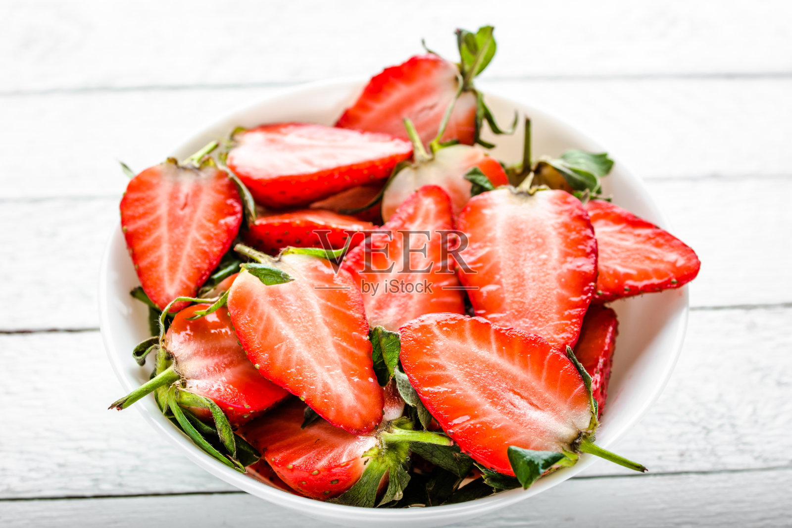 新鲜的草莓。盛有多汁的草莓沙拉，切片水果照片摄影图片