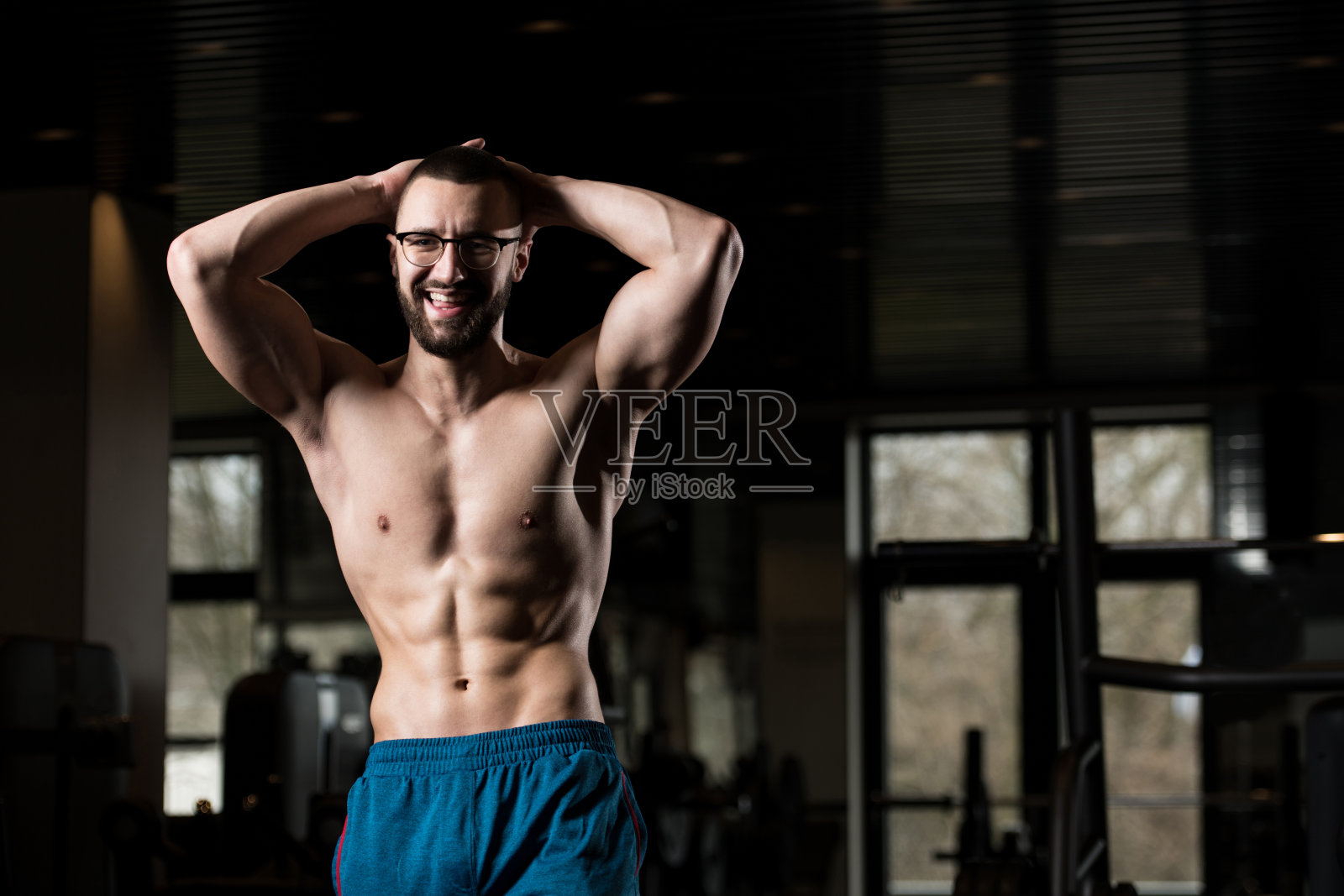 年轻的健美运动员戴眼镜锻炼肌肉照片摄影图片