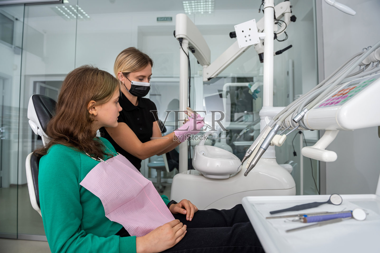 牙科医生在牙科诊所向病人展示如何在下颌模型上刷牙照片摄影图片