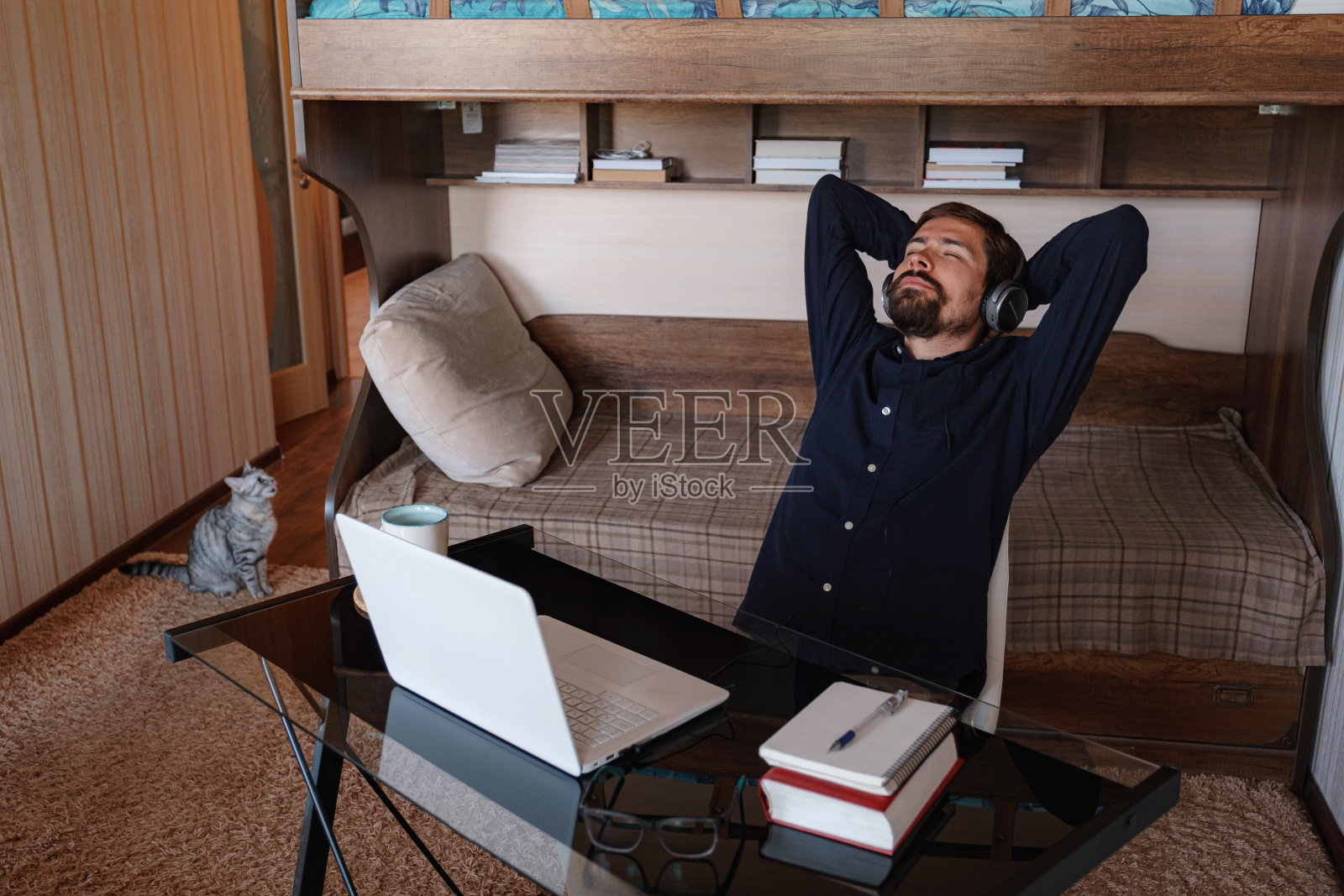 满意的商人戴着耳机在家享受音乐照片摄影图片