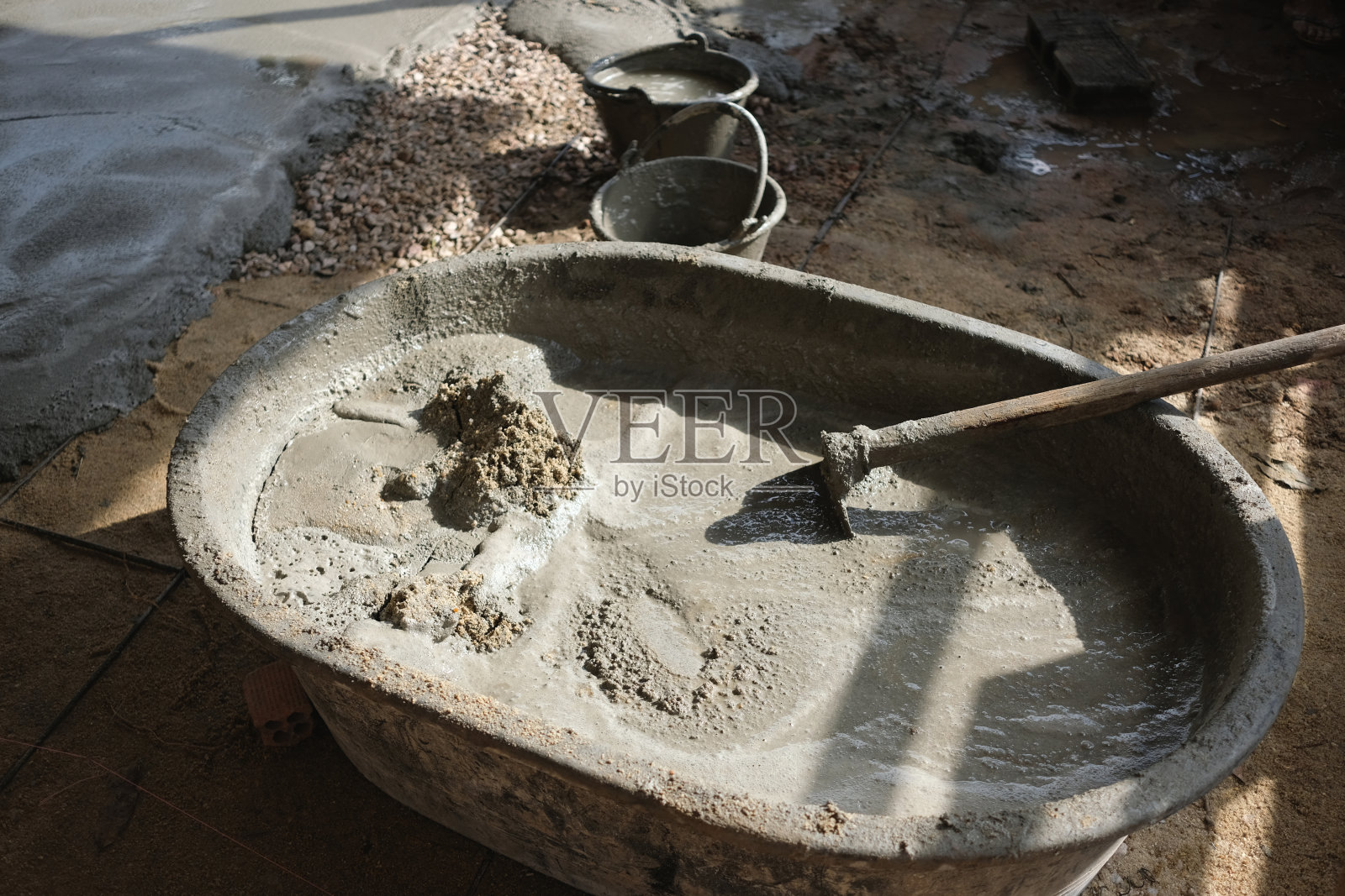 灰浆和水混合在一个大桶里照片摄影图片