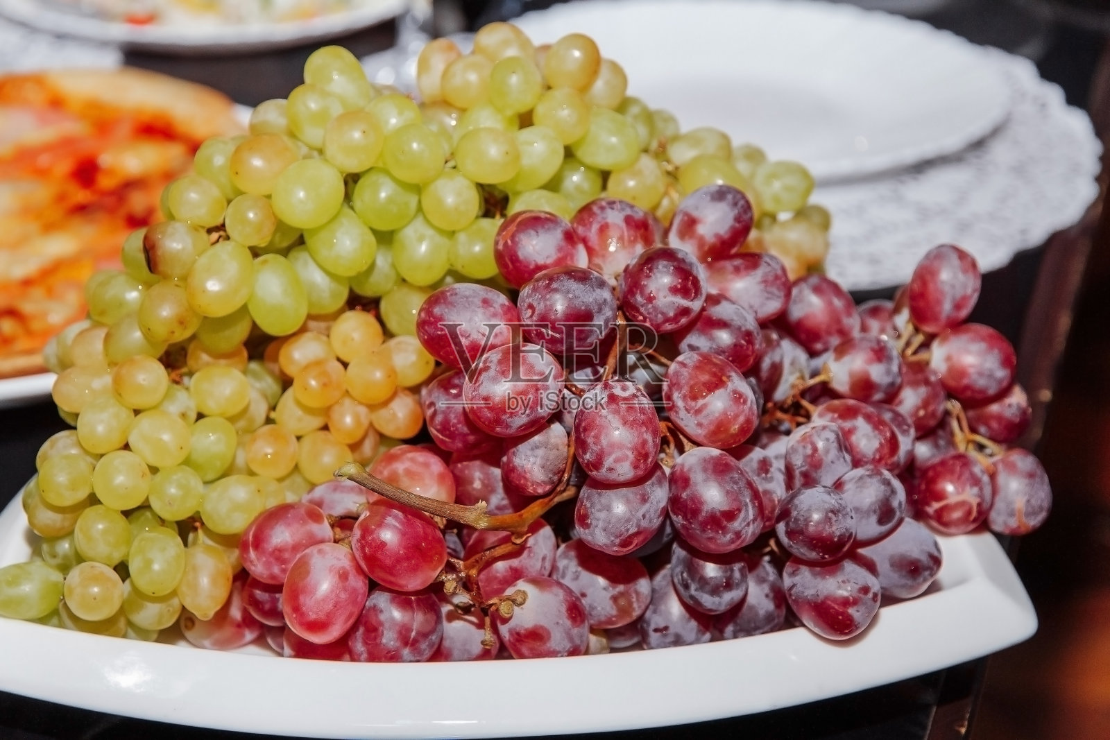 红色和绿色的葡萄在盘子里。照片摄影图片