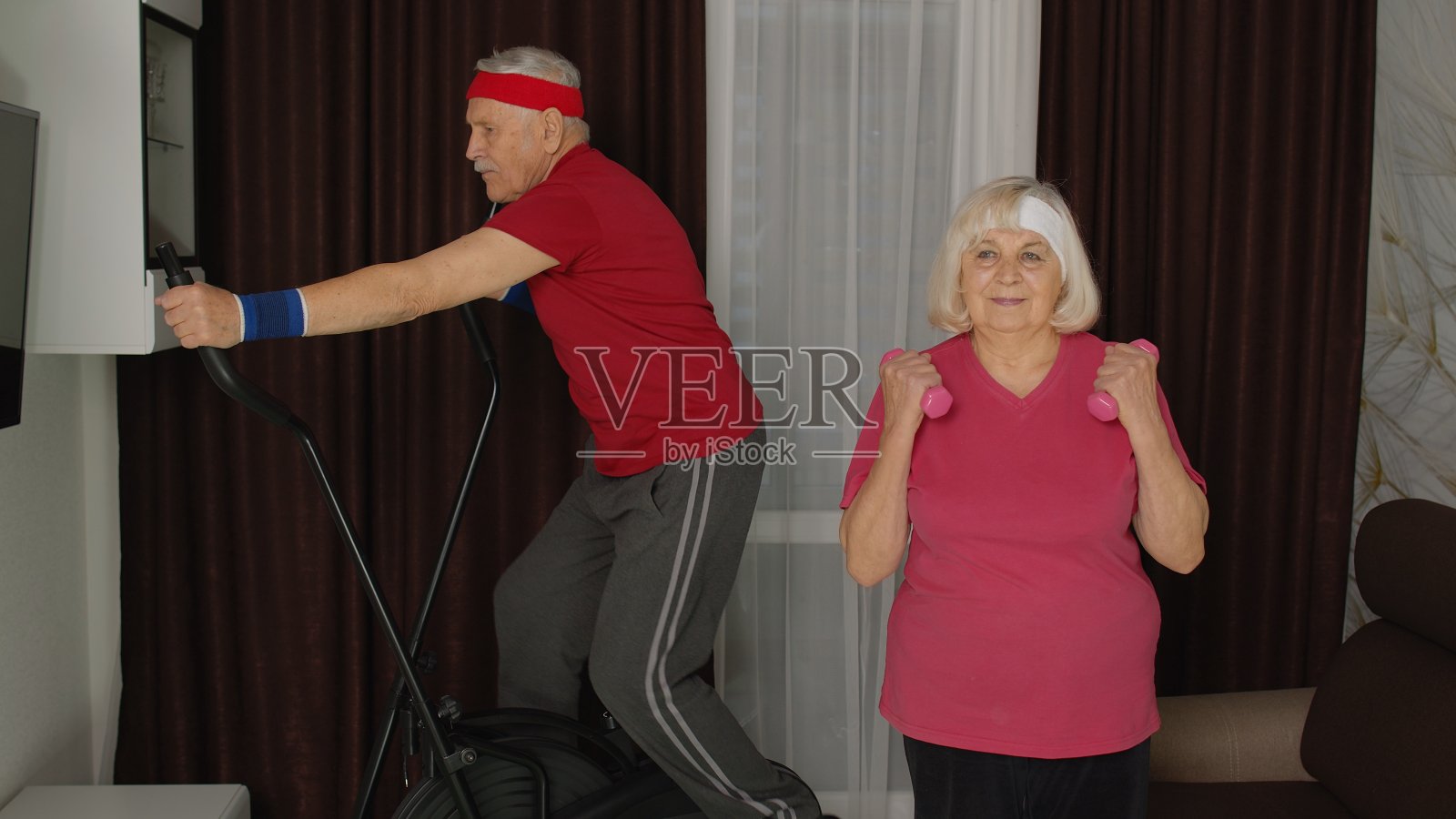 年事已高的老爷爷和老奶奶用orbitrek，做哑铃举重练习照片摄影图片
