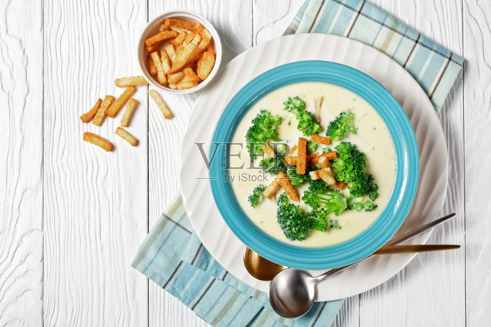 奶油汤，花椰菜和面包丁，白色木桌，勺子和餐巾，从上往下看照片摄影图片