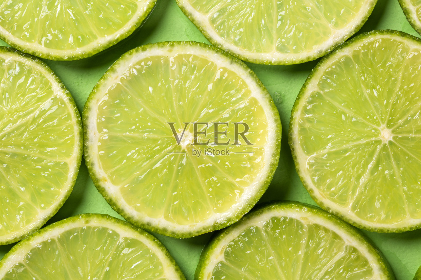 一片新鲜多汁的绿色柠檬。纹理背景,模式照片摄影图片