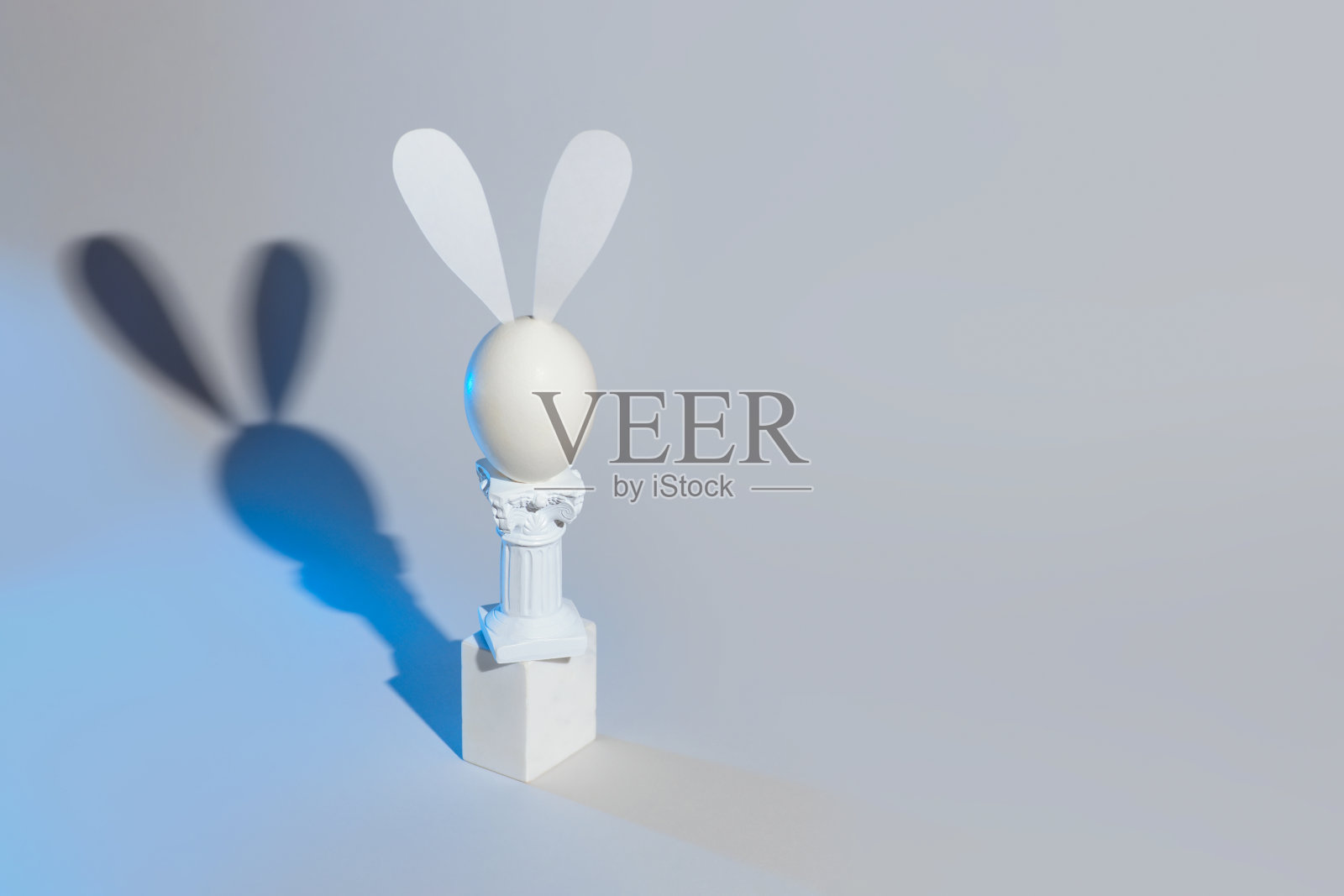 复活节兔子的蛋和柱子在一个灰色的背景。照片摄影图片