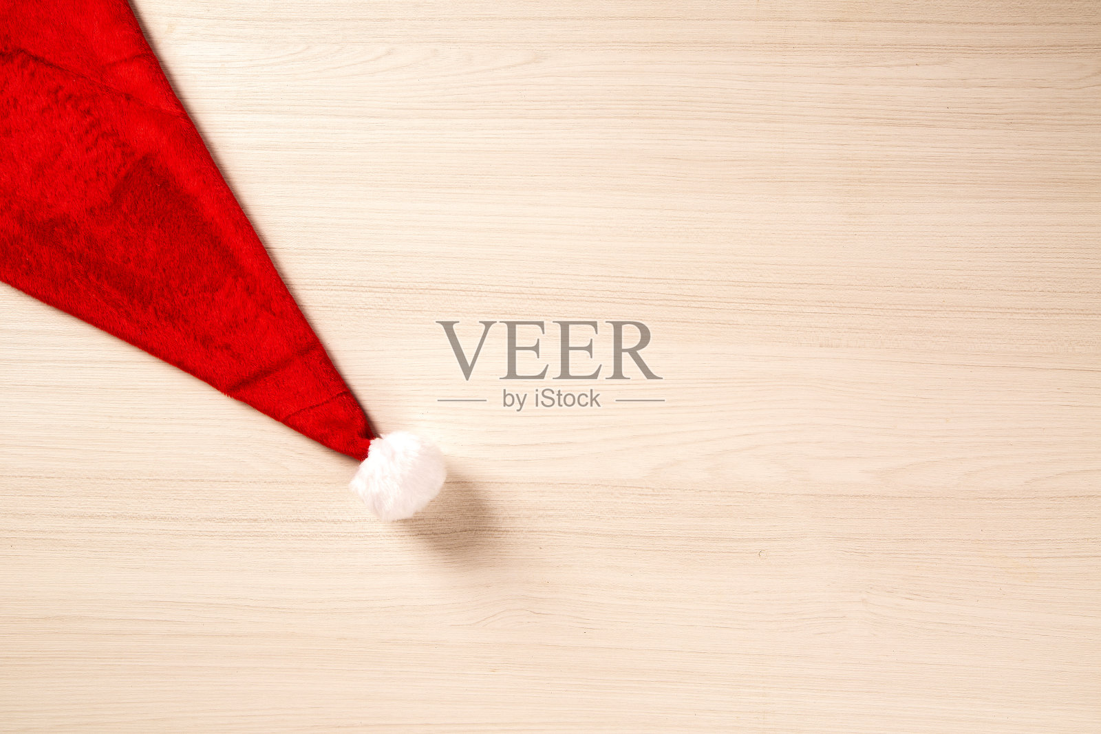 圣诞老人的帽子放在木板上。圣诞节的背景。照片摄影图片