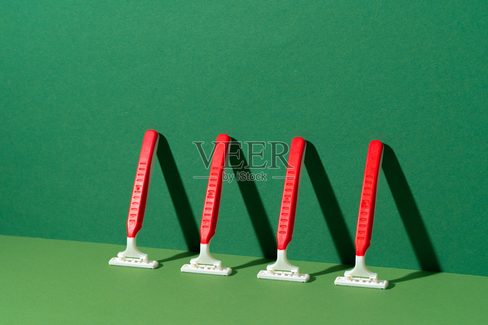 一次性剃须刀在绿色背景，工作室拍摄照片摄影图片