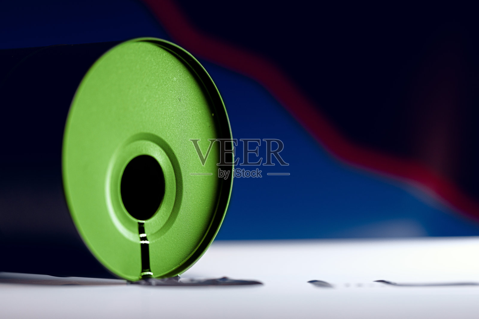 石油工业的概念。白色背景上的一个小桶里溢出的油照片摄影图片