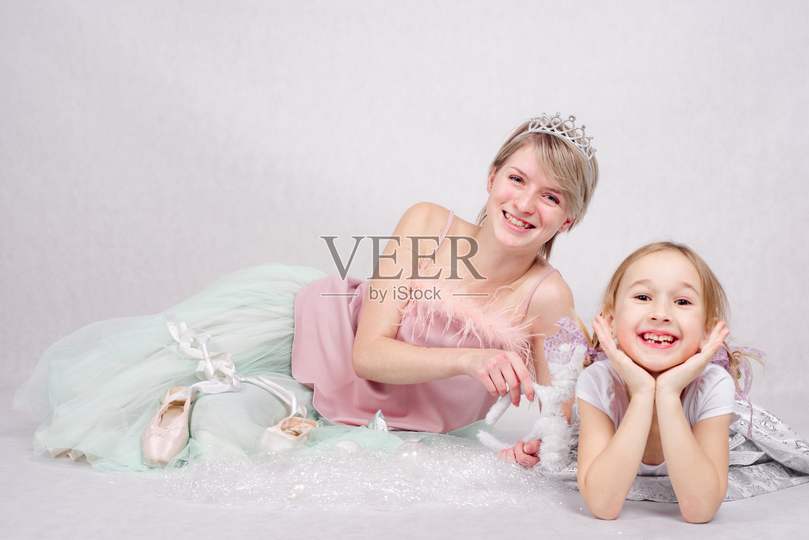 妈妈带着一个穿着漂亮衣服，背景是白色的孩子。照片摄影图片