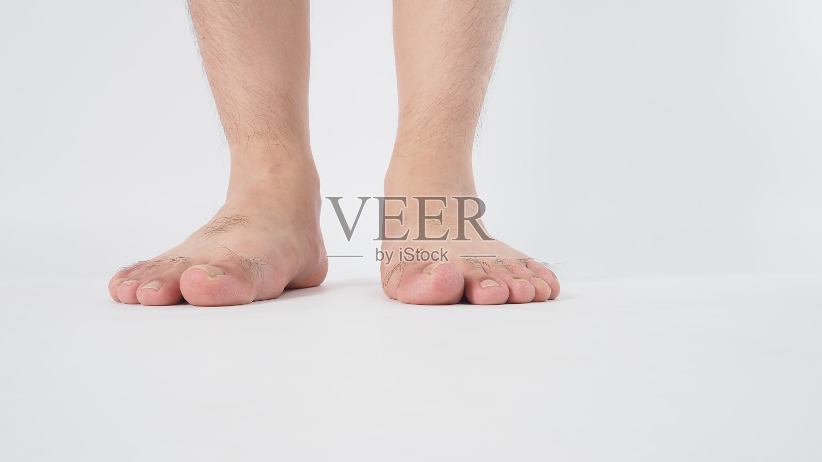 男性的腿和赤脚是孤立的白色背景。照片摄影图片