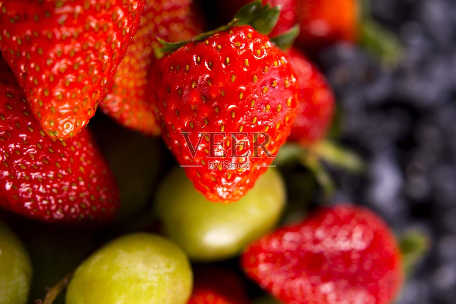 水果背景-新鲜多汁美味的草莓，蓝莓和葡萄。照片摄影图片