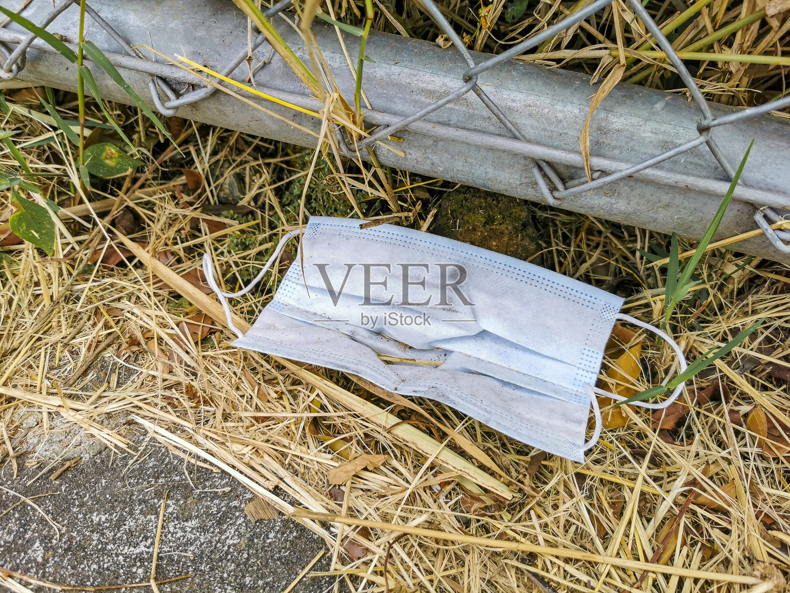 地上有肮脏的蓝色面具。冠状病毒污染。Covid19。照片摄影图片