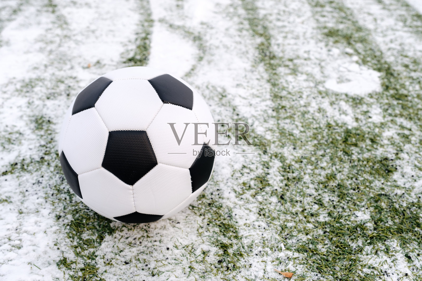 冬天在雪地上踢足球照片摄影图片