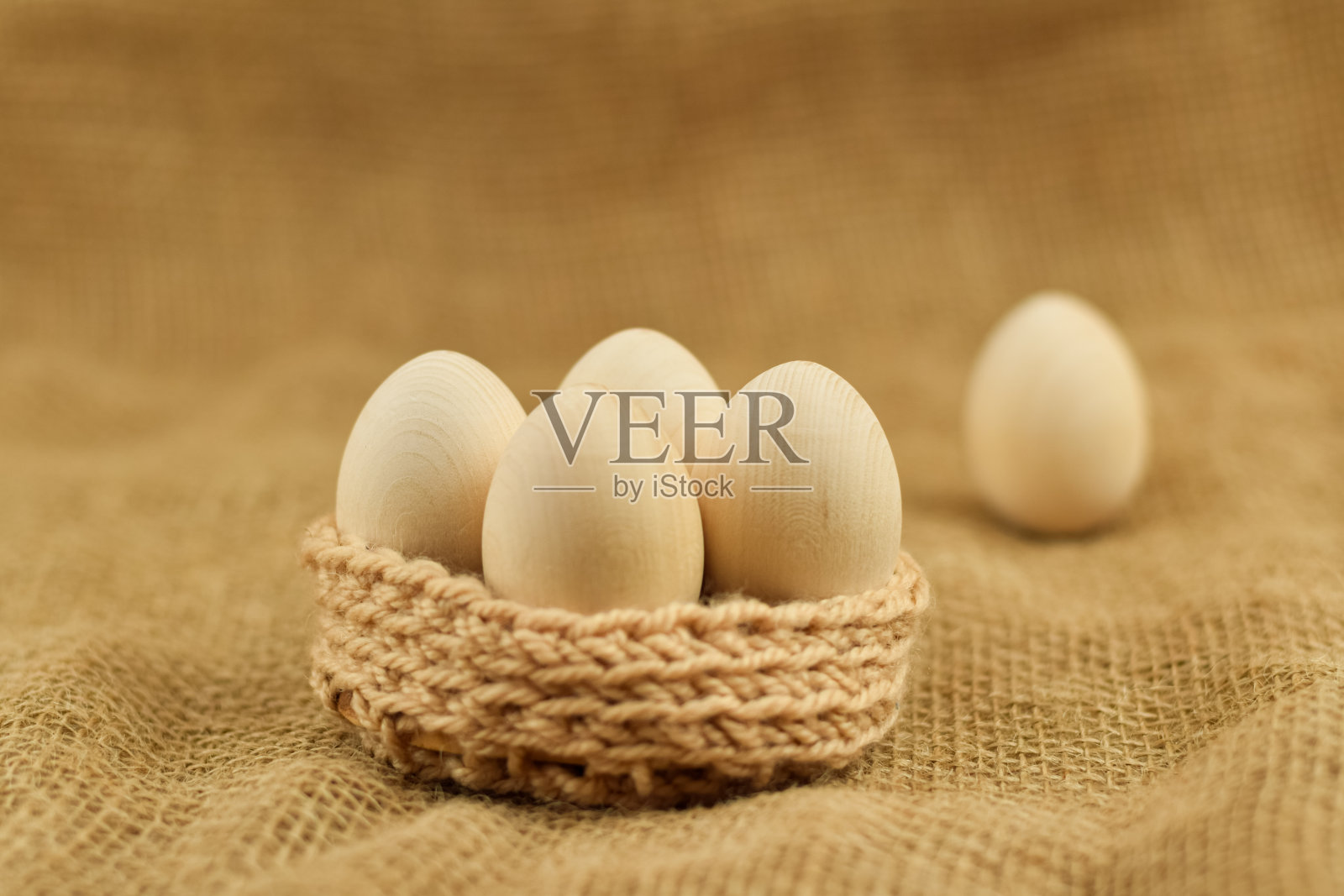 装饰用的木制复活节彩蛋放在柳条篮子里。鸡蛋的特写在一个古老的背景。春天的复活节假期。背景。零浪费复活节理念与传统装饰。环保生活，复制空间照片摄影图片