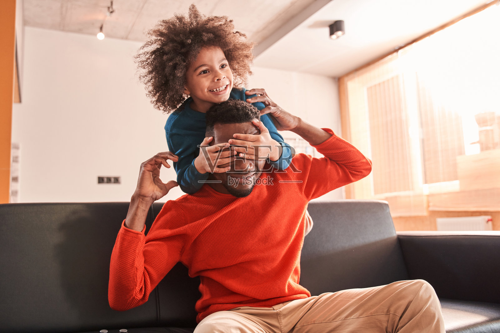 坐在沙发上的混血儿闭上了他父亲的眼睛照片摄影图片