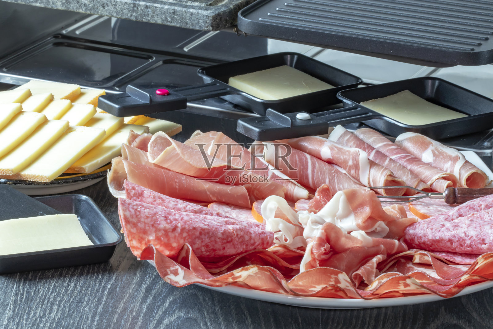 各种肉类和raclette奶酪照片摄影图片