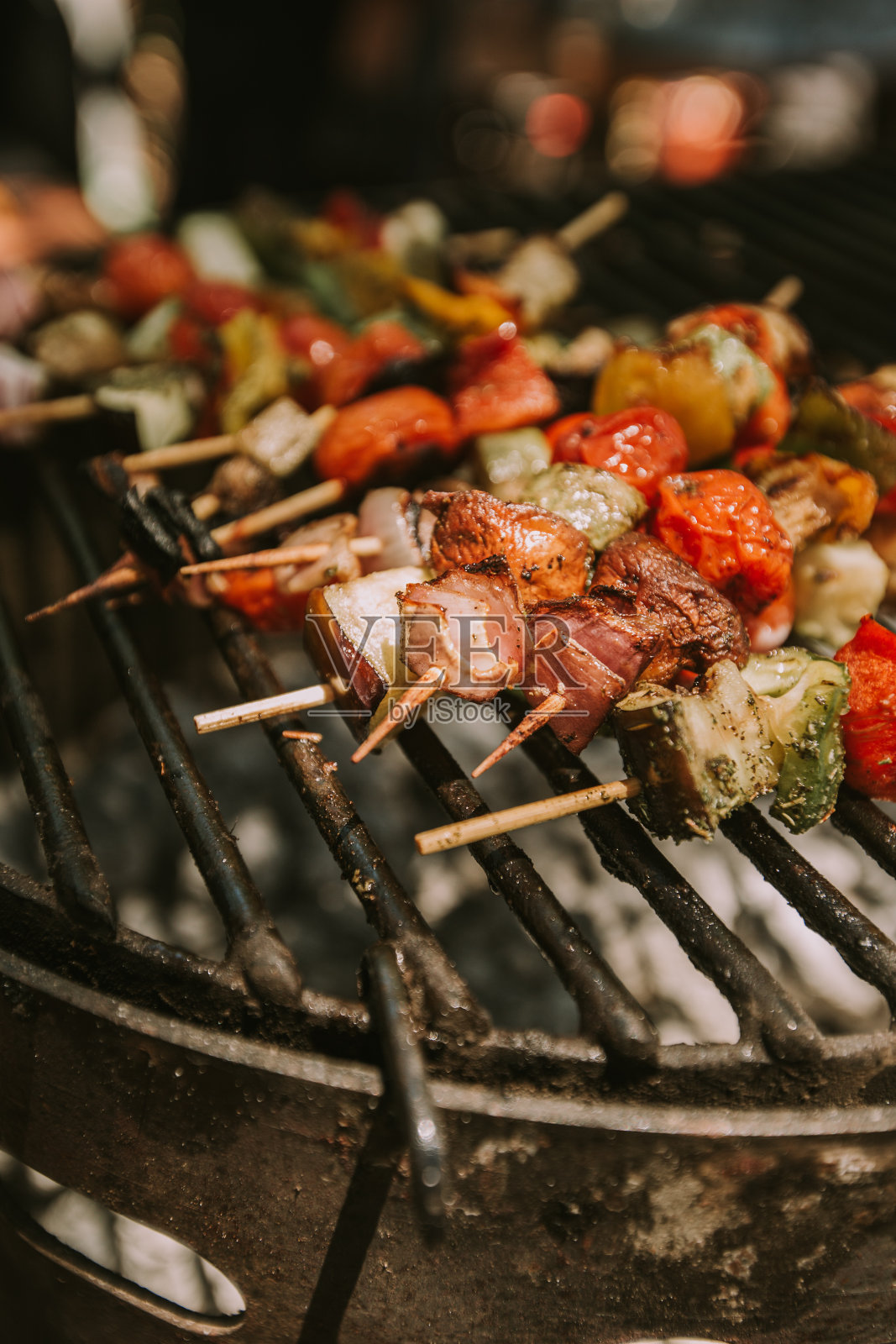 黑烤架上的虾和蔬菜串。照片摄影图片