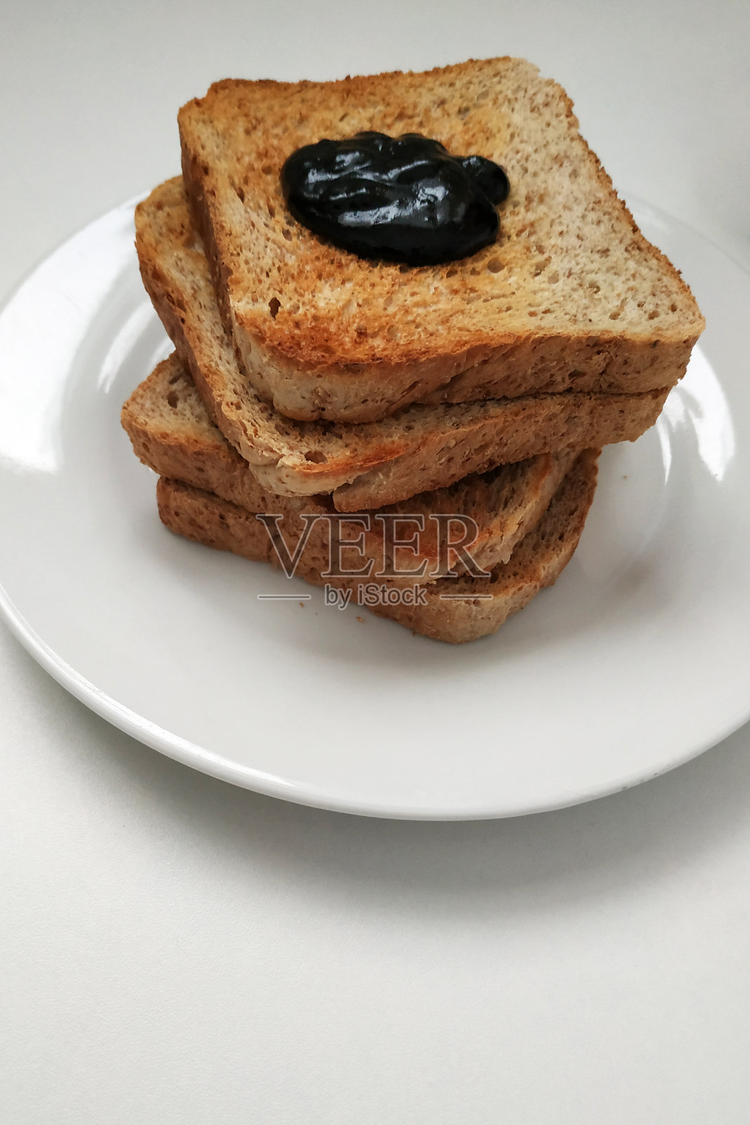 早餐是香脆的巧克力，白色的盘子里放着吐司和巧克力。照片摄影图片