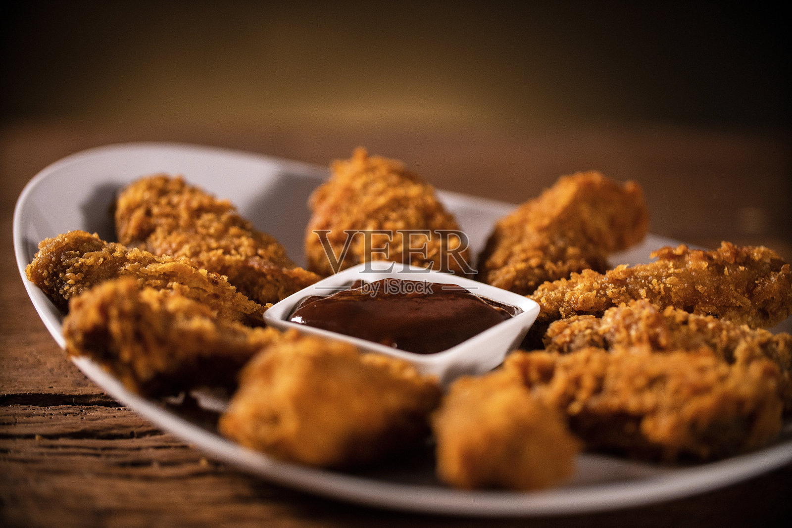 一桶香脆的肯德基炸鸡，配上烟熏和烧烤酱。有选择性的重点。照片摄影图片