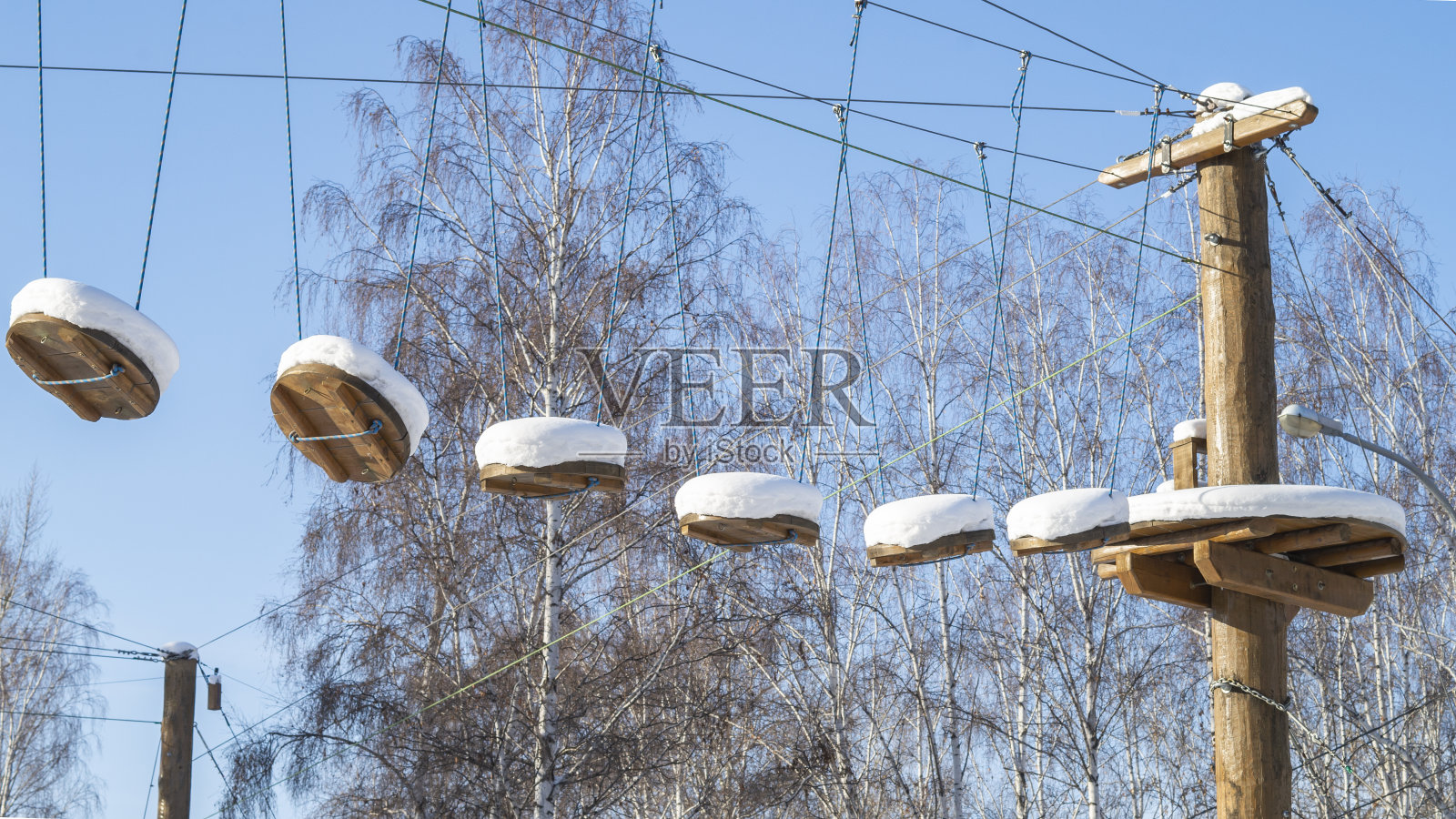 冬天的风景。悬索桥上的河在雪天的映衬下照片摄影图片