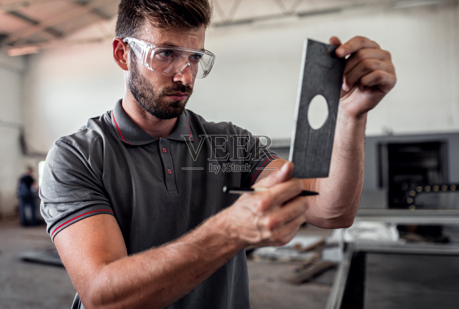 年轻工程师在金属加工车间安装等离子切割机。照片摄影图片